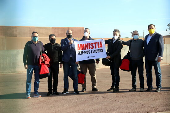Seven of the nine jailed pro-independence leaders outside Lledoners prison hold a sign calling for an amnesty (by Mar Martí)